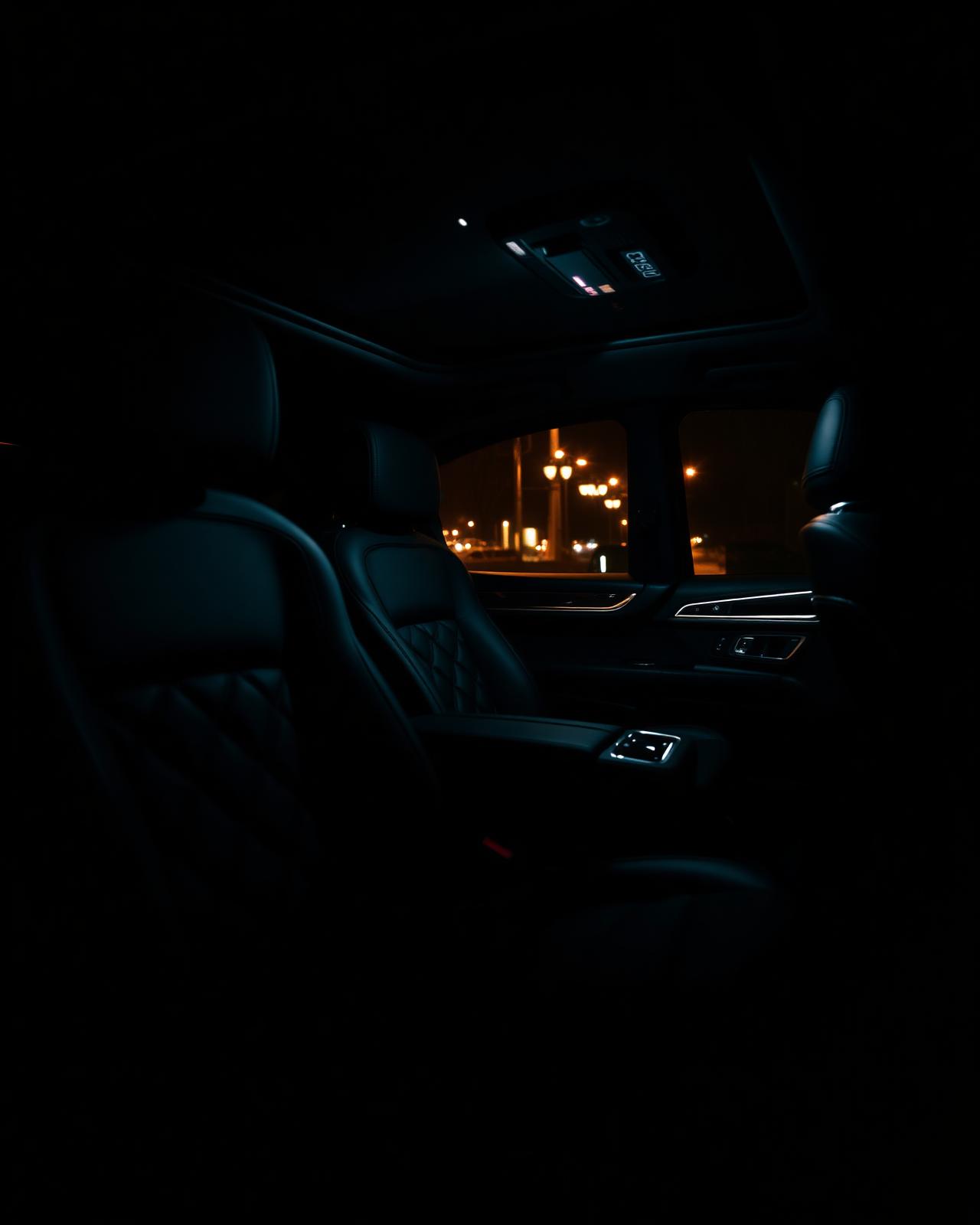 Quilted leather interior of a luxury SUV lit by warm ambient light